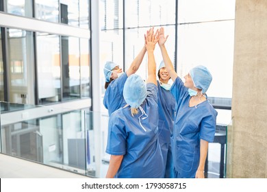 Successful group of surgeons at the hospital gives themselves a high five for motivation