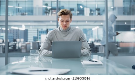 Successful Handsome Businessman Working on Laptop Computer in Big City Office. Finance Investment Analyst Checking Analytics from Project Management Reports, Answering Emails, Checking Social Media.