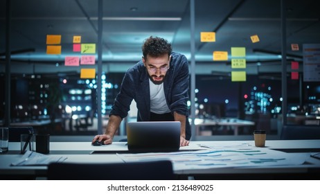 Successful Handsome Creative Director Working on Laptop Computer in Big City Office Late in the Evening. Businessman Preparing for a Marketing Plan in Conference Room. - Powered by Shutterstock