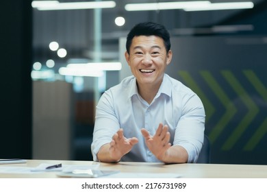 Successful And Happy Asian Businessman Looking At Camera, Talking On Video Call, Cheerfully Gesticulating To Interlocutor, Online Meeting, Man Working In Office At Work