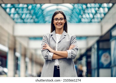 A successful happy businesswoman elegantly dressed standing at the business center with arms crossed. A proud, successful businesswoman at the business center