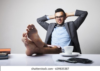 Successful Happy Young Businessman Sitting In Office With Bare Feet On Desk And Relaxing. (Boss, Business, Rules, Officialdom Concept)