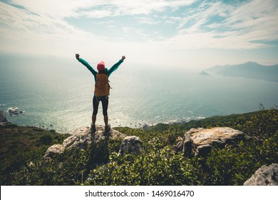 Successful hiker outstretched arms at seaside mountain top cliff edge - Powered by Shutterstock