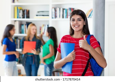 Successful hispanic female student with group of multi ethnic college students at classroom of university
