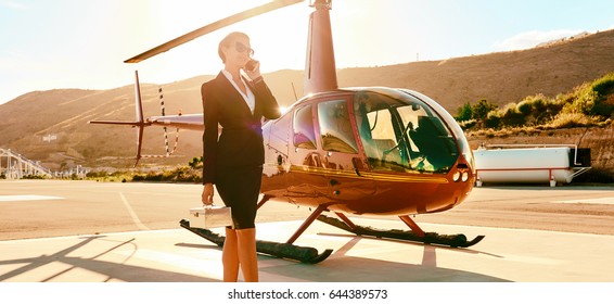 Successful Intelligent Smart Elegant Young Businesswoman Talk By Phone Near Helicopter, Mountains Sunny Day. Woman In Business, Ceo Director Female, Success, Career, Good Deal Luxury Lifestyle Concept