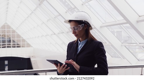 Successful intelligent woman architect standing at new office center using tablet to look at building plan drawing. Female engineer working at construction site. - Powered by Shutterstock