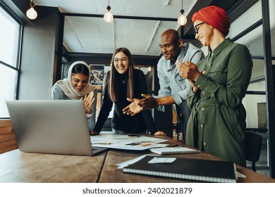 Successful interior designers applauding cheerfully during an online meeting. Group of multicultural businesspeople celebrating their achievement during a video conference.