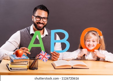 Successful kid student girl smile while playing with English letters with teacher, children language education concept