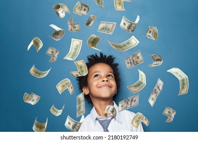 Successful Little Black Kid Boy Standing Under Us Dollar Money Rain On Blue Background