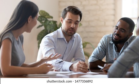 Successful male corporate leader explain new project plan talk to diverse team people training staff at meeting, serious boss teach multiracial workers discuss paperwork at group office briefing - Powered by Shutterstock