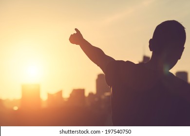 Successful Man aiming at Sunset