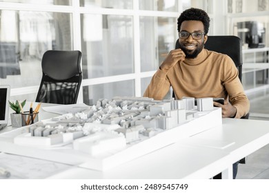 Successful man architect reviewing blueprints in his workplace - Powered by Shutterstock