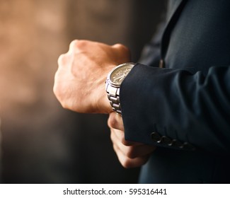 successful man keeps watch and clothes - Shutterstock ID 595316441
