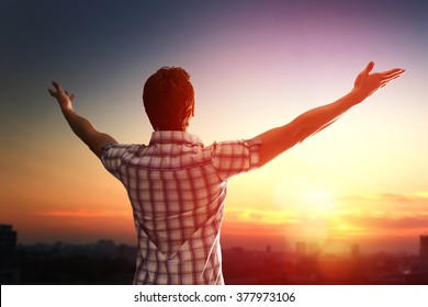 Successful man looking up to sunset sky celebrating enjoying freedom. Positive human emotion feeling life perception success, peace of mind concept. Free happy man