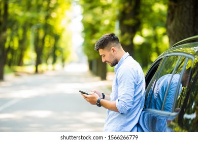 Successful Man Standing By His Car Texting On Mobile Phone