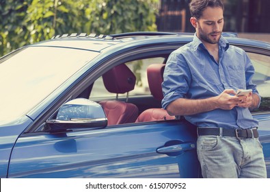 Successful Man Standing By His Car Texting On Mobile Phone 