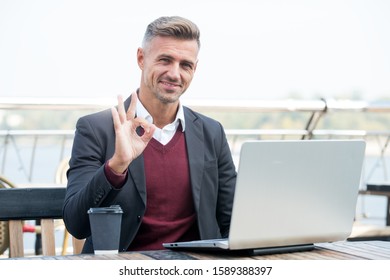 Successful Man Working In Cafe. Good Morning Vibes. Modern Life Concept. Businessman Out Of Office. Agile Business. Use Laptop While Drink Coffee. Ordinary Working Day. Smiling Man Show Ok Gesture.