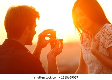 Successful Marriage Proposal At Sunset. Man Offering Engagement Ring To His Glad Girlfriend