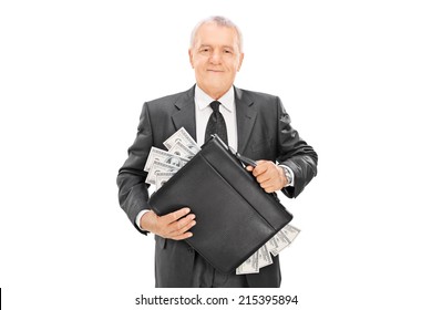 Successful mature businessman holding briefcase full of money isolated on white background