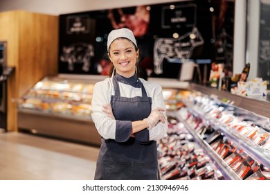 Successful meat department worker at supermarket smiling at the camera. - Shutterstock ID 2130946946