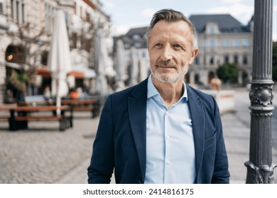 Successful Modern Bestager Businessman Standing at a City Square in Summer, Gazing Confidently into the Future. - Powered by Shutterstock