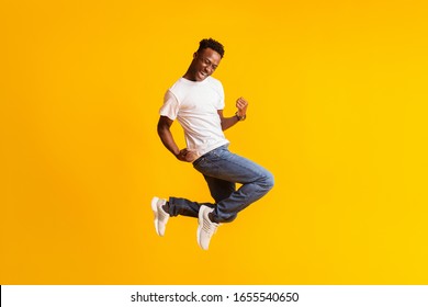 Successful moment. Happy excited young black man jumping over yellow background, copy space - Shutterstock ID 1655540650