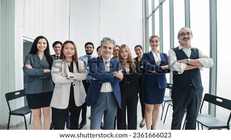 Successful multiethnic businessteam standing with arms crossed at modern office. Happy diverse professional business team standing in office looking at camera. Human resource concept