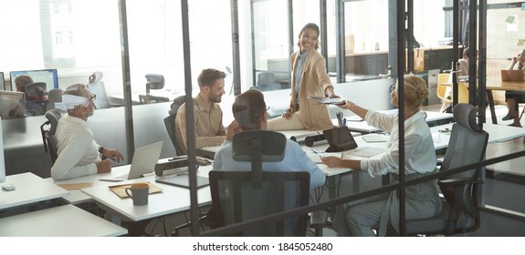 Successful multiracial project team sitting in conference room and discussing business while working together in the modern office or coworking space - Shutterstock ID 1845052480