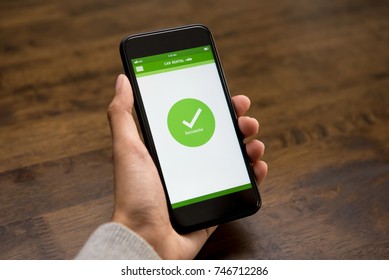 Successful Online Car Rental Confirmation Sign Appears On Smartphone Screen After Booking Digitally By A Woman Customer