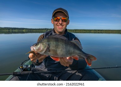 Successful perch fishing. Smiling fisherman with big perch fish on boat