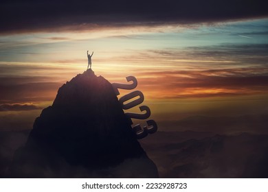 Successful person celebrates on the top of 2023 year mountain peak. Conceptual and motivational scene inspiring for overcoming challenges. Courageous winner man raises arms victorious - Shutterstock ID 2232928723