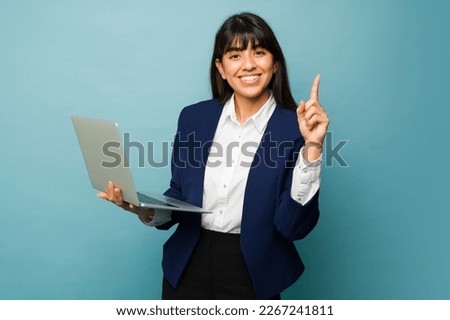 Successful professional woman showing her finger saying number one business while smiling and working on the computer