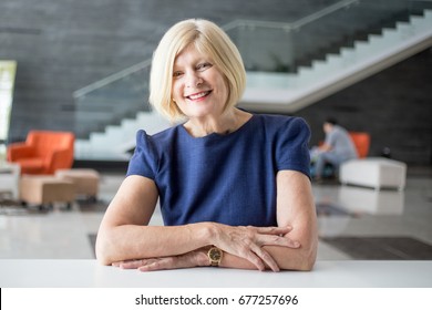 Successful Senior Hotel Owner Leaning On Counter