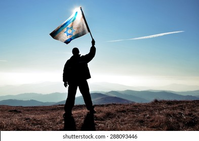 Successful Silhouette Man Winner Waving Israel Flag On Top Of The Mountain Peak