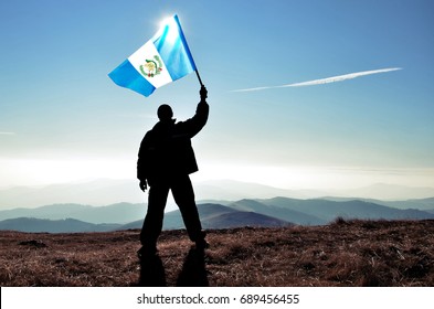 Successful Silhouette Man Winner Waving Guatemala Flag On Top Of The Mountain Peak