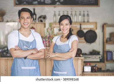 Successful small business owner proudly standing in front of their cafe - Powered by Shutterstock