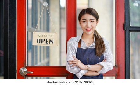 Successful Small Business Startup Small Business Owner SME Beauty Girl Standing In Front Of A Coffee Shop With Her Arms Crossed. Picture Of An Asian Female Barista Cafe Owner. 