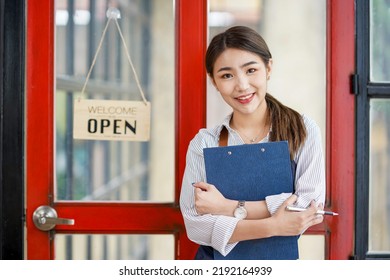 Successful Small Business Startup Small Business Owner SME Beauty Girl Standing In Front Of A Coffee Shop With Her Arms Crossed. Picture Of An Asian Female Barista Cafe Owner. 