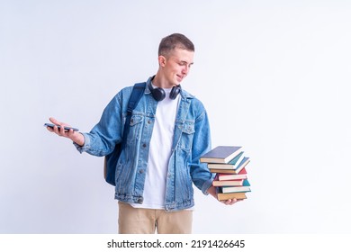 successful student with backpack, headphones with stack of books and smartphone in his hands on a white background. the guy gets knowledge, higher education. Admission to a university or college.