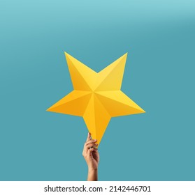 Successful and Talent Concept, Hand Raise up a Golden Star into the blue Sky 