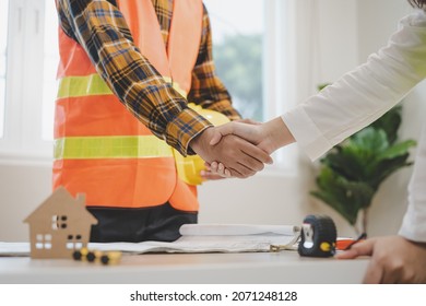 Successful Team Building Asian Young Woman, Man Or Builder Group Handshake Together At Office After Home Project Done, Good Deal. Happy Business People, Worker Meeting, Shaking Hands And Success.