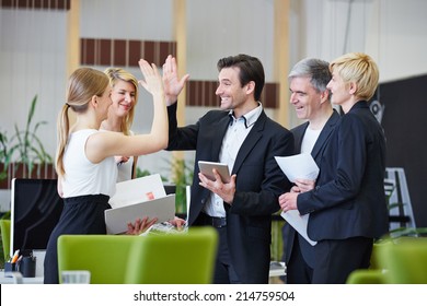 Successful team of business people giving high five in the office