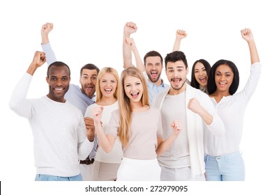 Successful Team. Group Of Happy Young People In Smart Casual Wear Looking At Camera And Keeping Arms Raised While Standing Against White Background