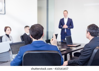 Successful team leader and business owner  leading informal in-house business meeting. Businessman working on laptop in foreground. Business and entrepreneurship concept.