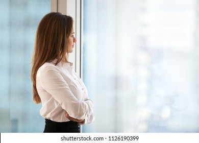 Successful Thoughtful Woman Business Leader Looking Out Of Big Window Enjoying City View And Wellbeing Feeling Motivated For New Goals, Rich Millennial Businesswoman Dreaming Of Future, Copy Space