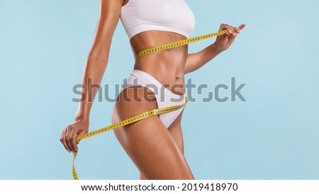 Successful Weightloss And Dieting. Closeup Of Slim Lady Measuring Waist With Tape, Happy About Her Body Parameters, Standing Isolated Over Blue Studio Background. Slimming Concept. Banner