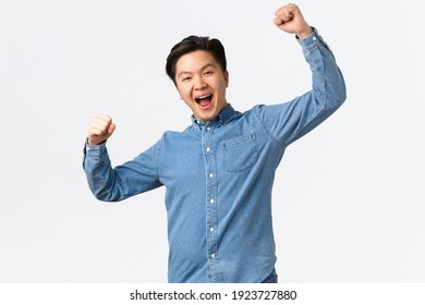 Successful winning man rejoicing over victory, raising hands up in hooray gesture, saying yes, achieving goal, winning prize, become champion and triumphing over great news, white background