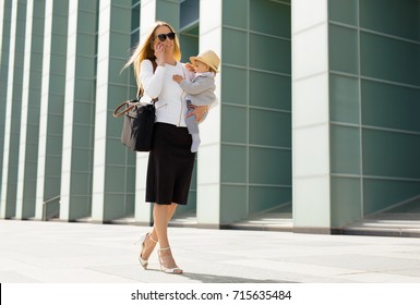 Successful woman going to work with baby in her hands