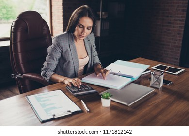 Successful woman in a gray checkered jacket checks documents on desktop before handing them over to the tax authorities industrial workplace
