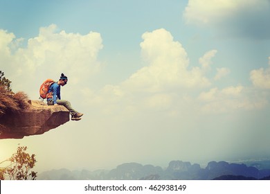 Successful woman hiker enjoy the view on mountain top cliff edge